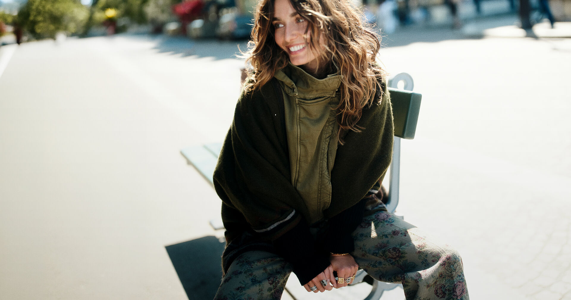 A model wearing a khaki coat, a poncho and several rings