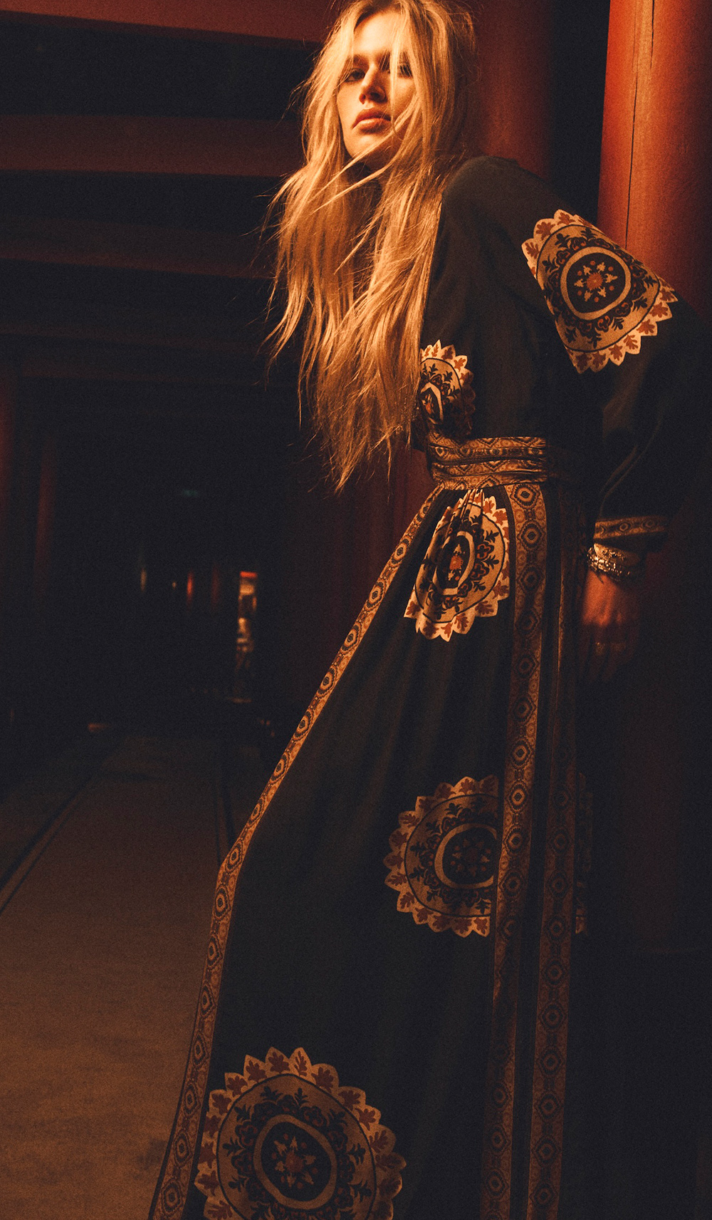 A blonde model wearing a printed dress and leather boots
