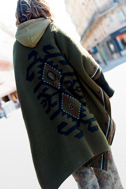 The model is wearing  a khaki poncho