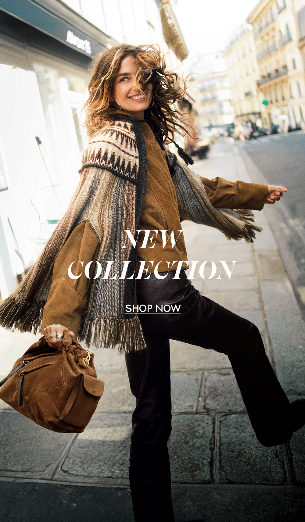 a model wearing a poncho and a bag