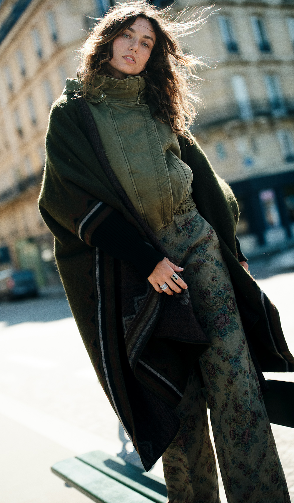 The model is wearing a poncho