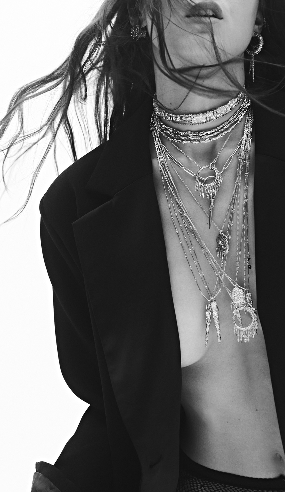 A model wearing ba&sh jewelry and a blazer, the photo is in black and white. 