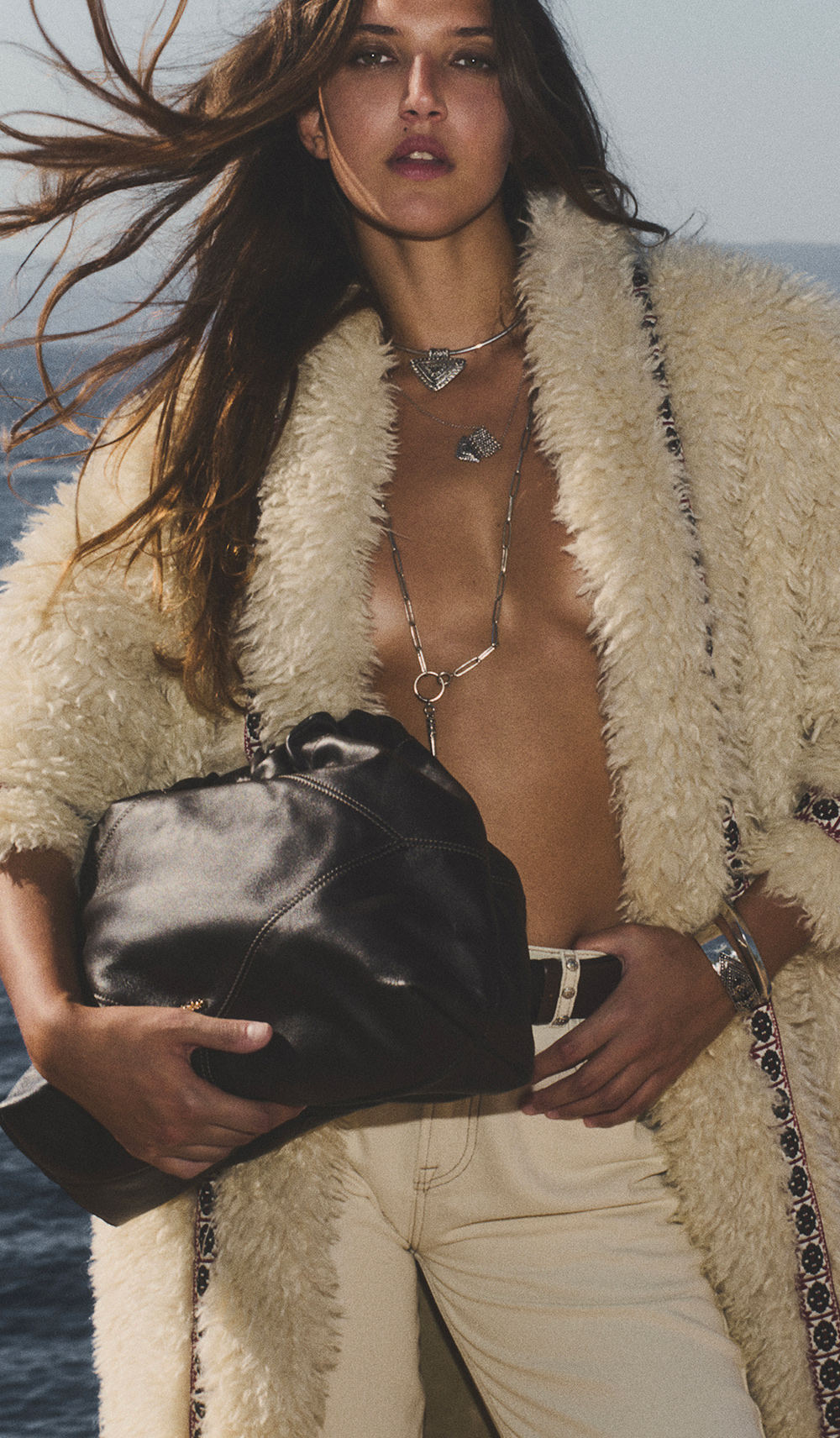 Black hair model wearing a white wool coat and the June tote bag