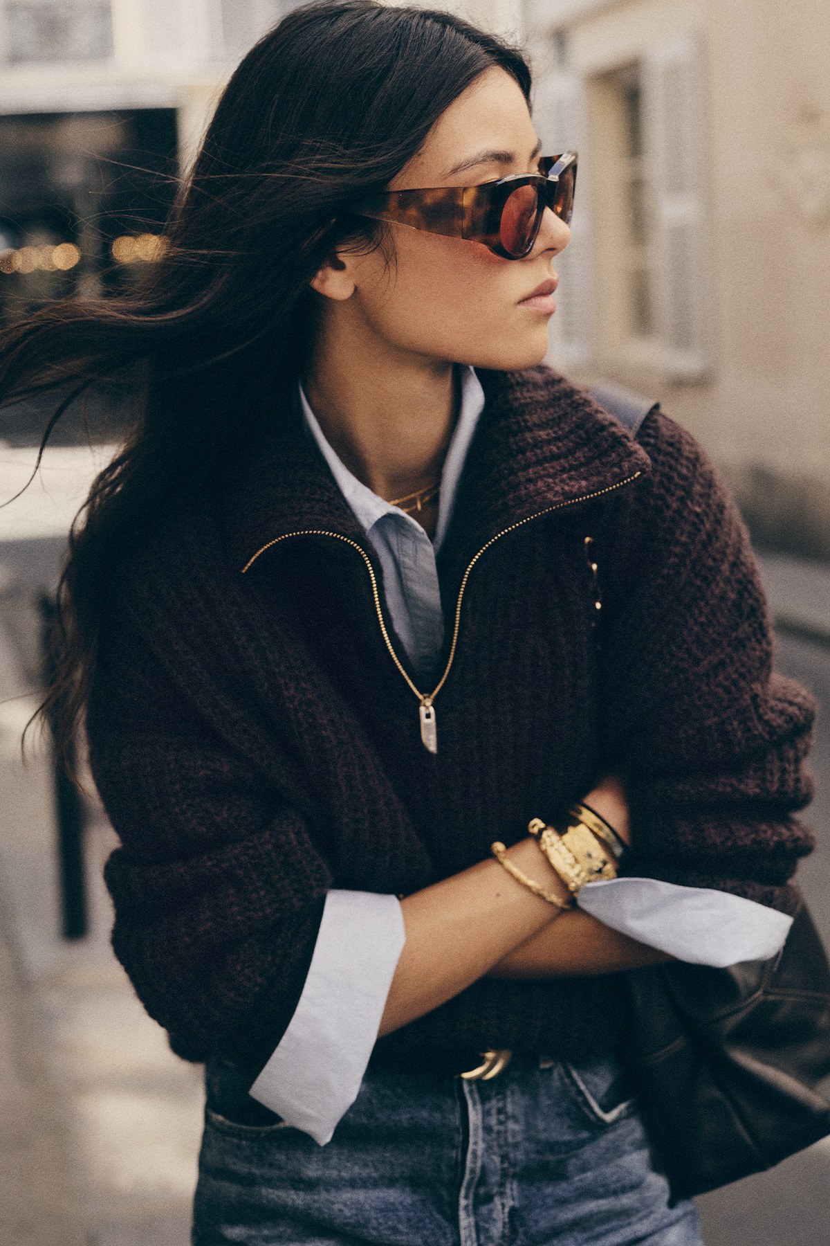 dark hair model wearing sun glasses and a knitted brown cardigan