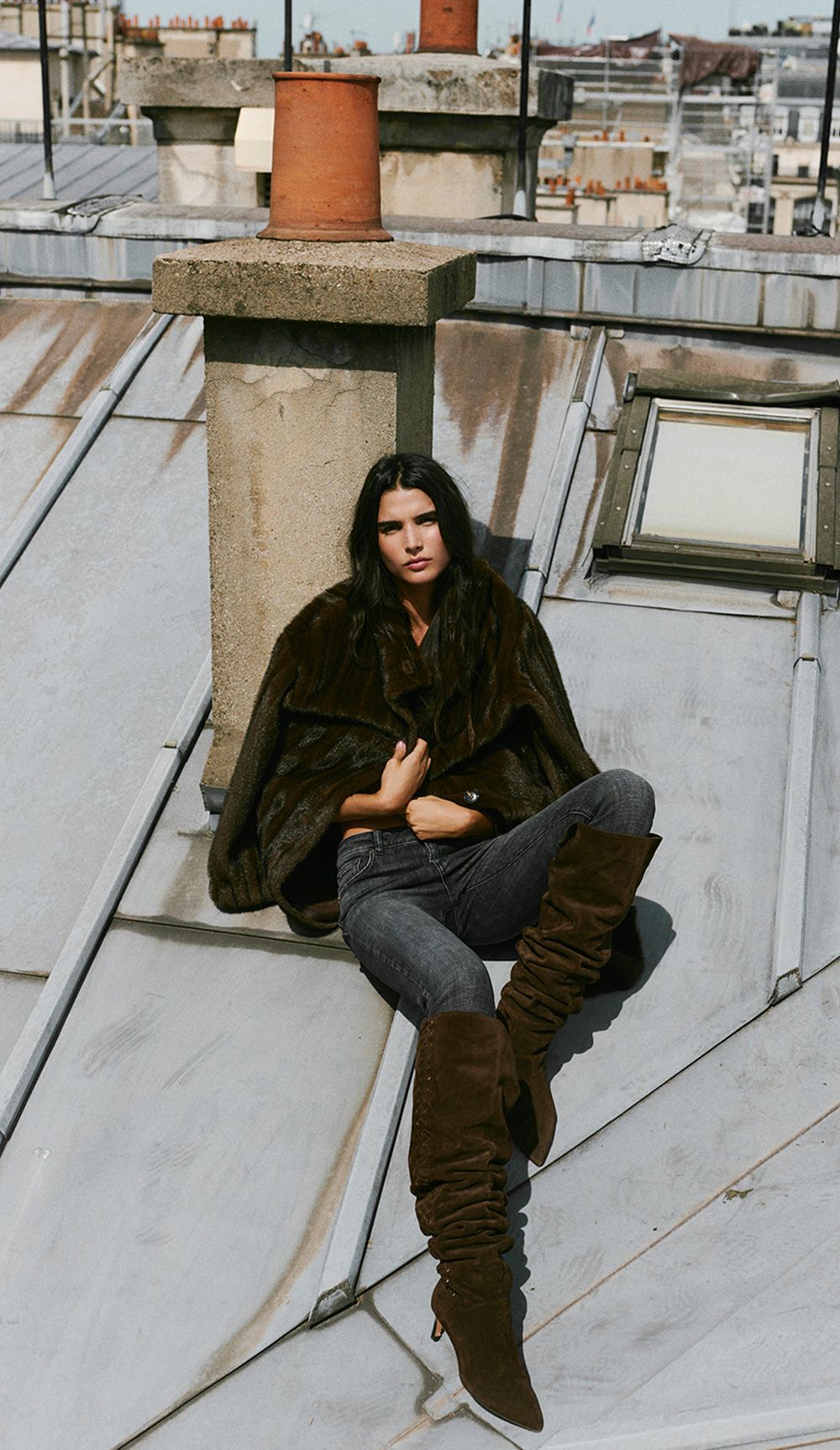 The model is wearing a pair of boots and jeans