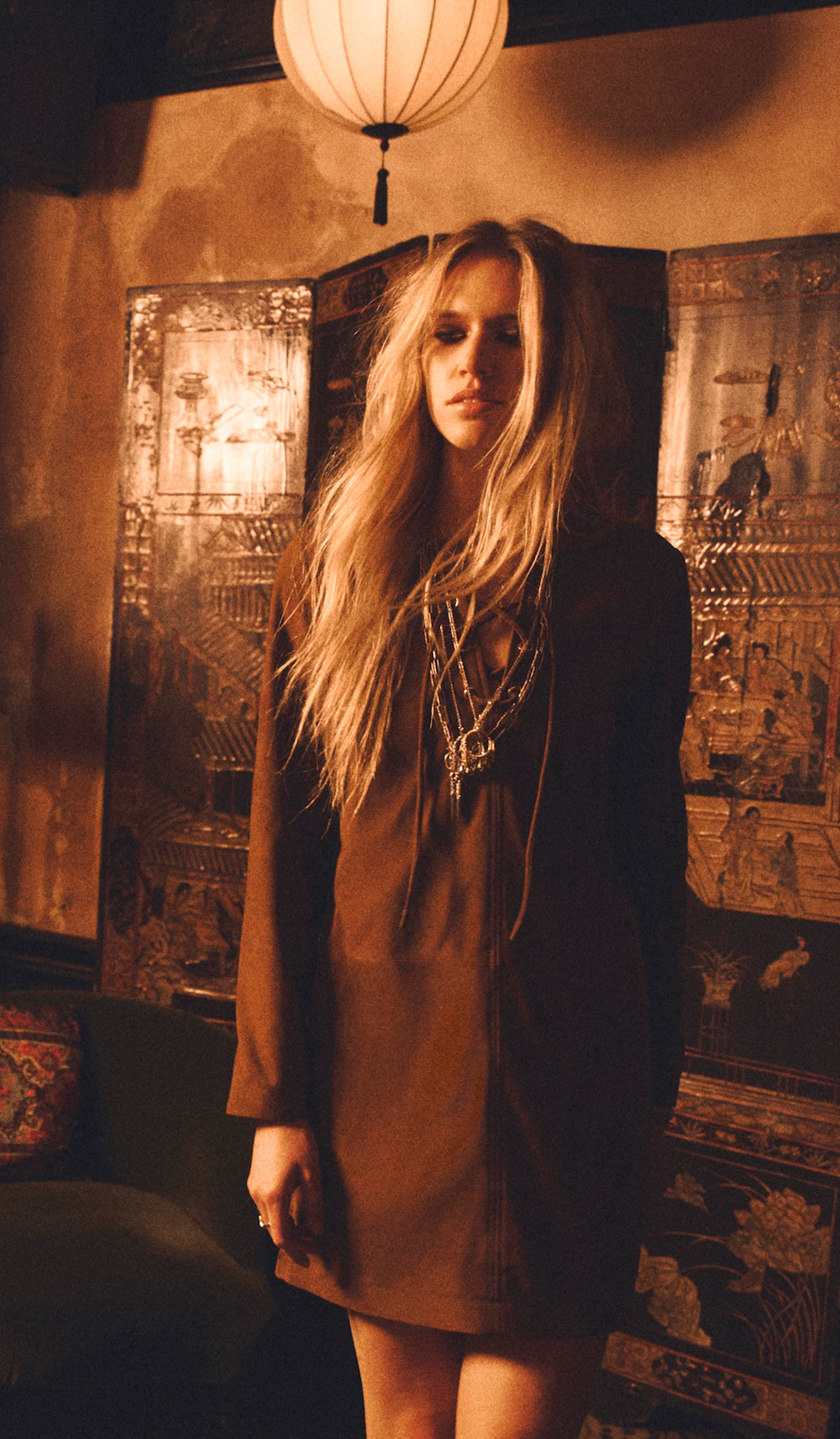 A blonde model wearing a cognac jacket suede leather dress