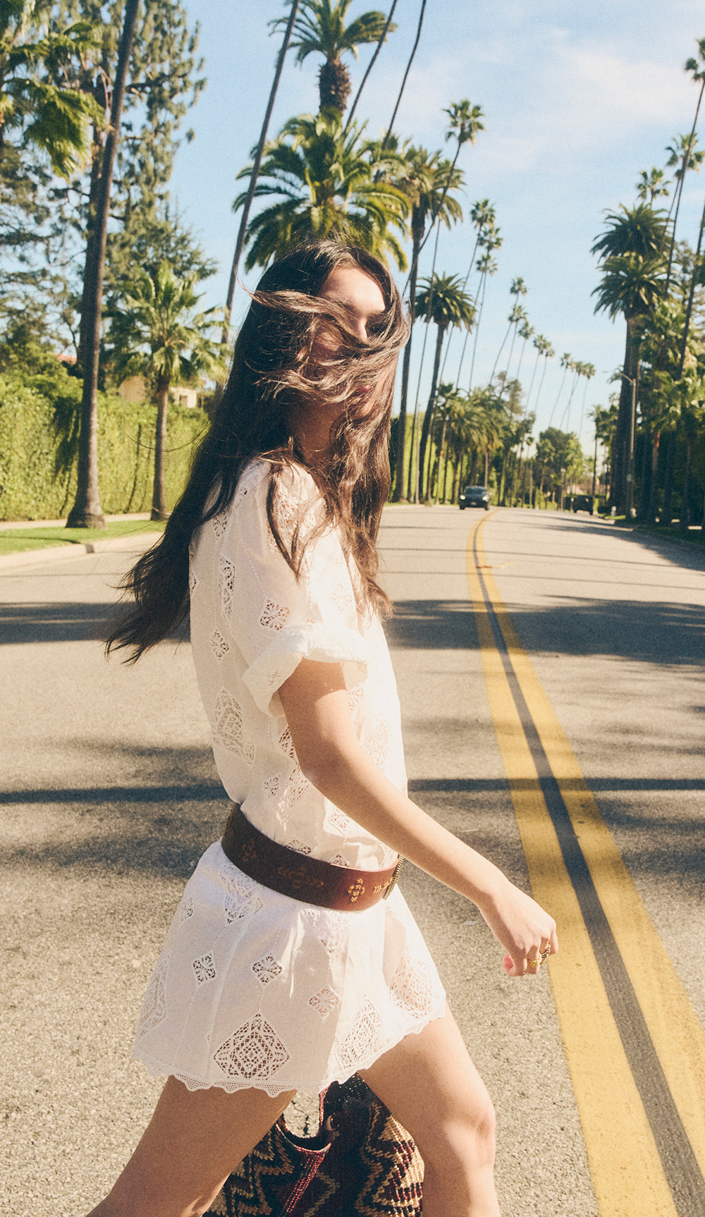 a model wearing a blouse and a skirt walking down the street 