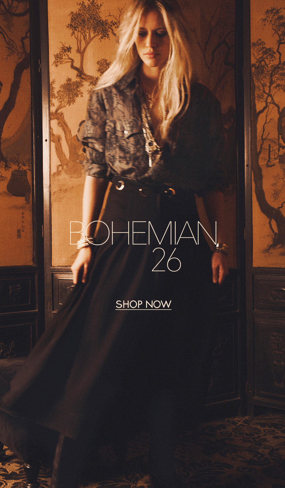 Blond model wearing a printed blouse with a black long skirt with leather boots