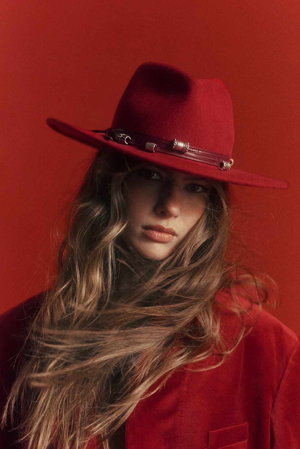 model wearing a red open back dress and red over the knee boots