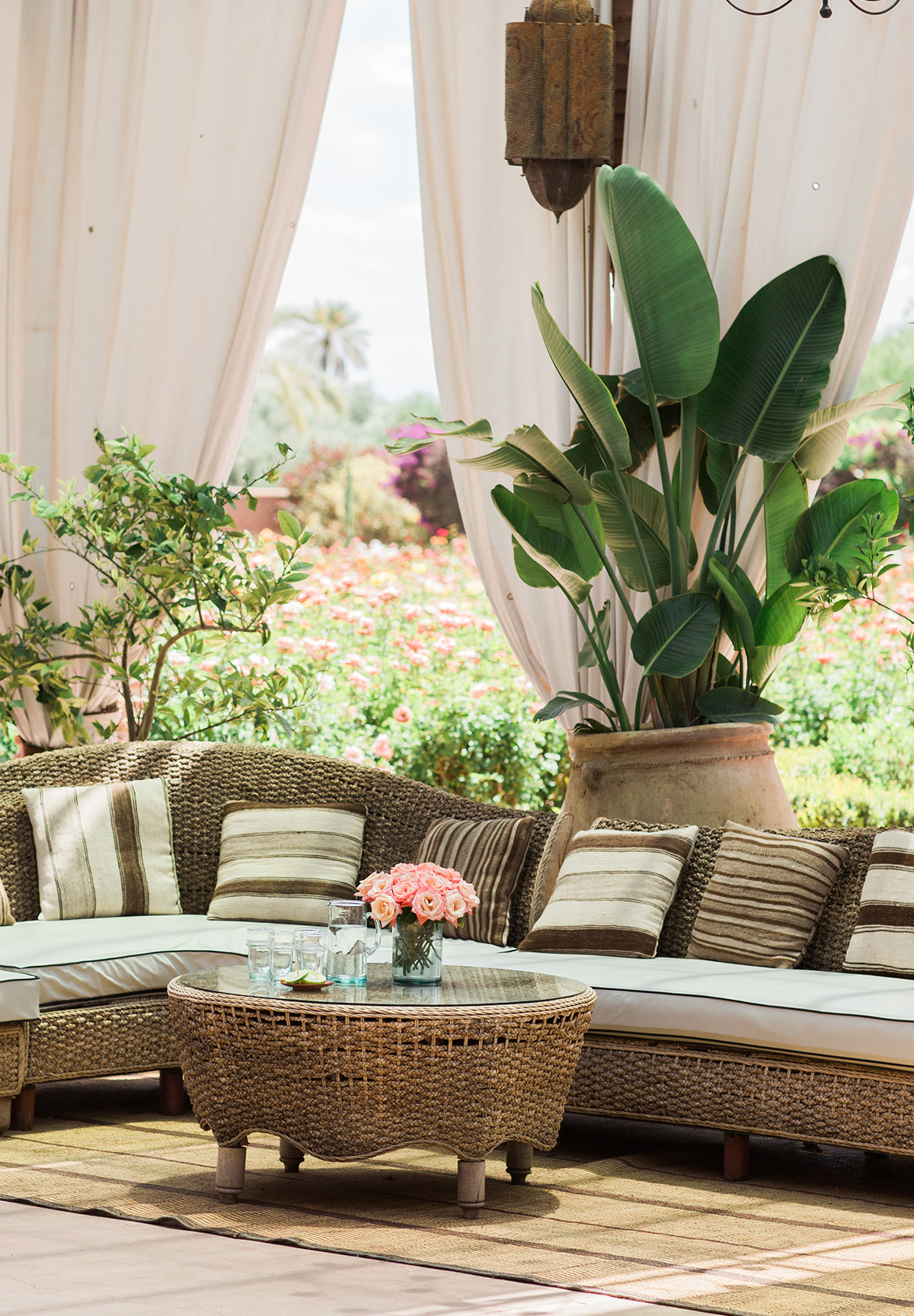 A terrace with a wicker sofa & white sails