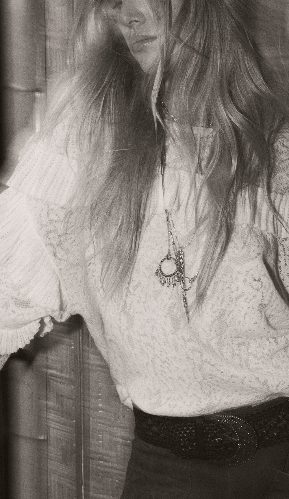 A blonde model wearing a white shirt with a ba&sh necklace