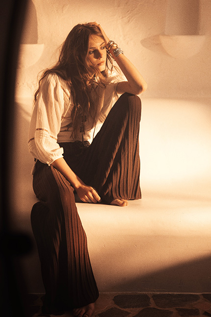 A model wearing a white top and brown pants
