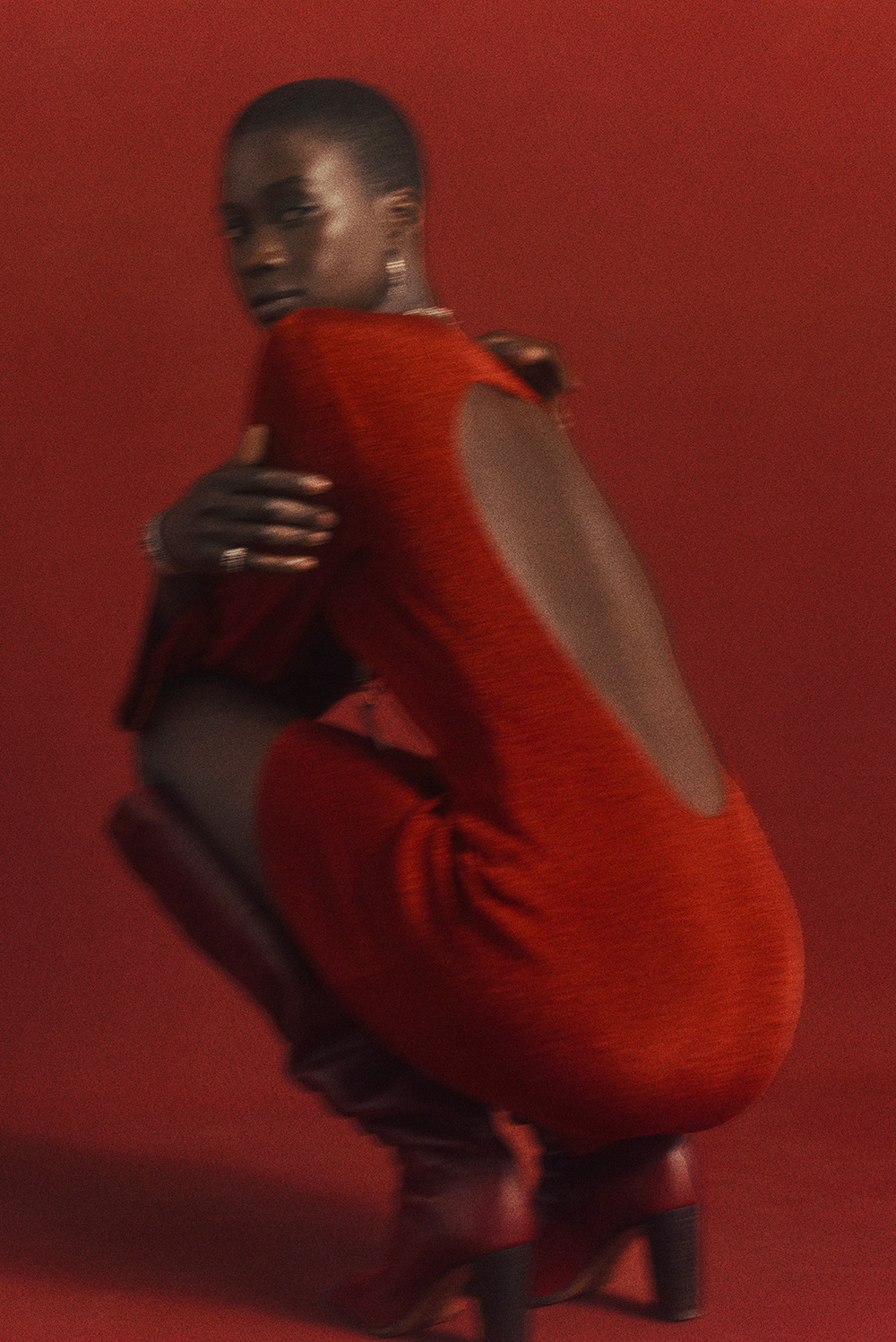 model wearing a red open back dress and red over the knee boots