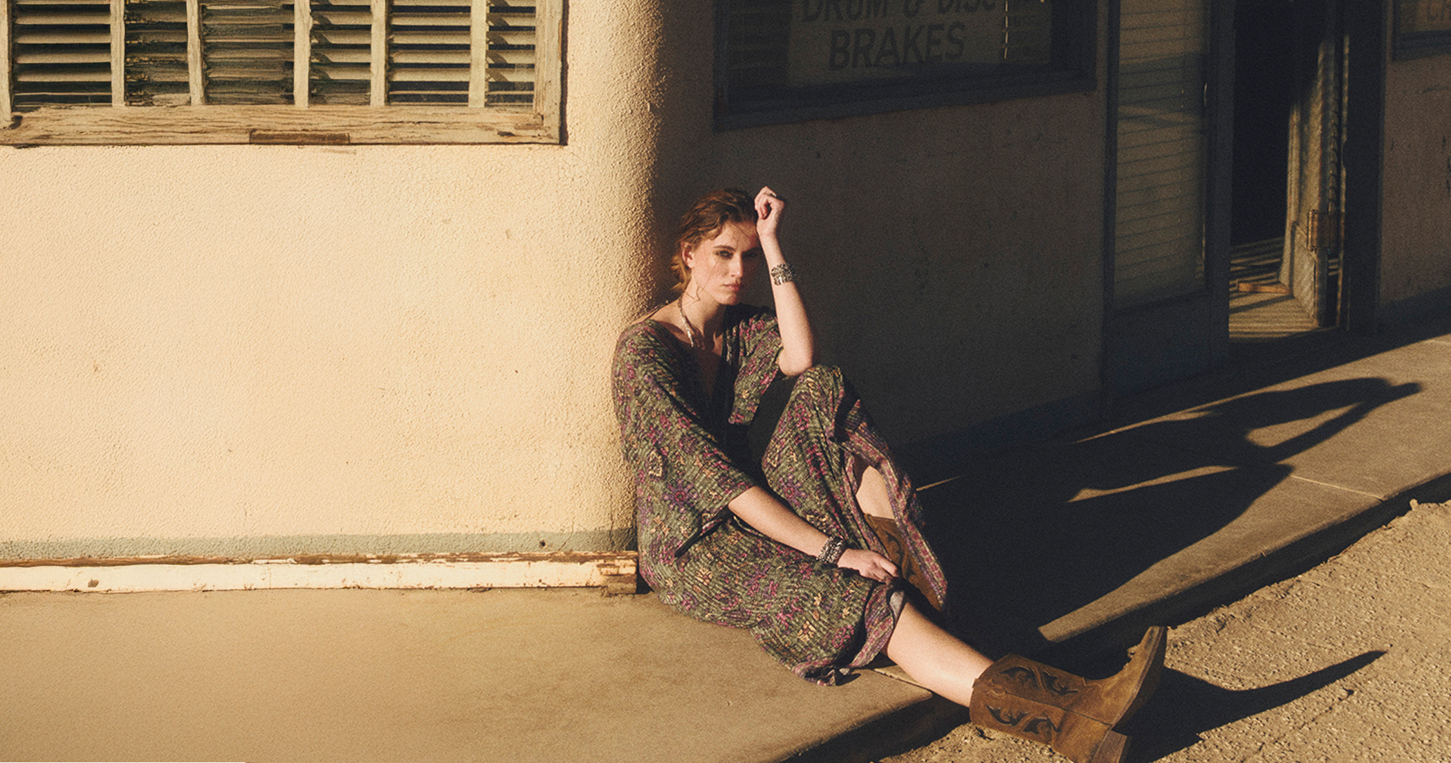 A model wearing a floral-print dress and boots