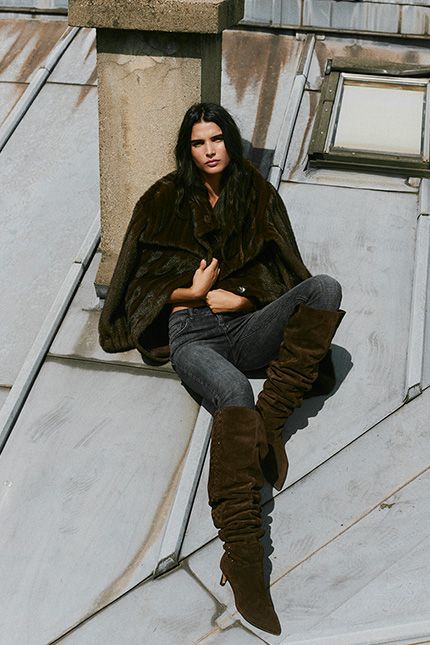 The model is wearing thigh-high boots