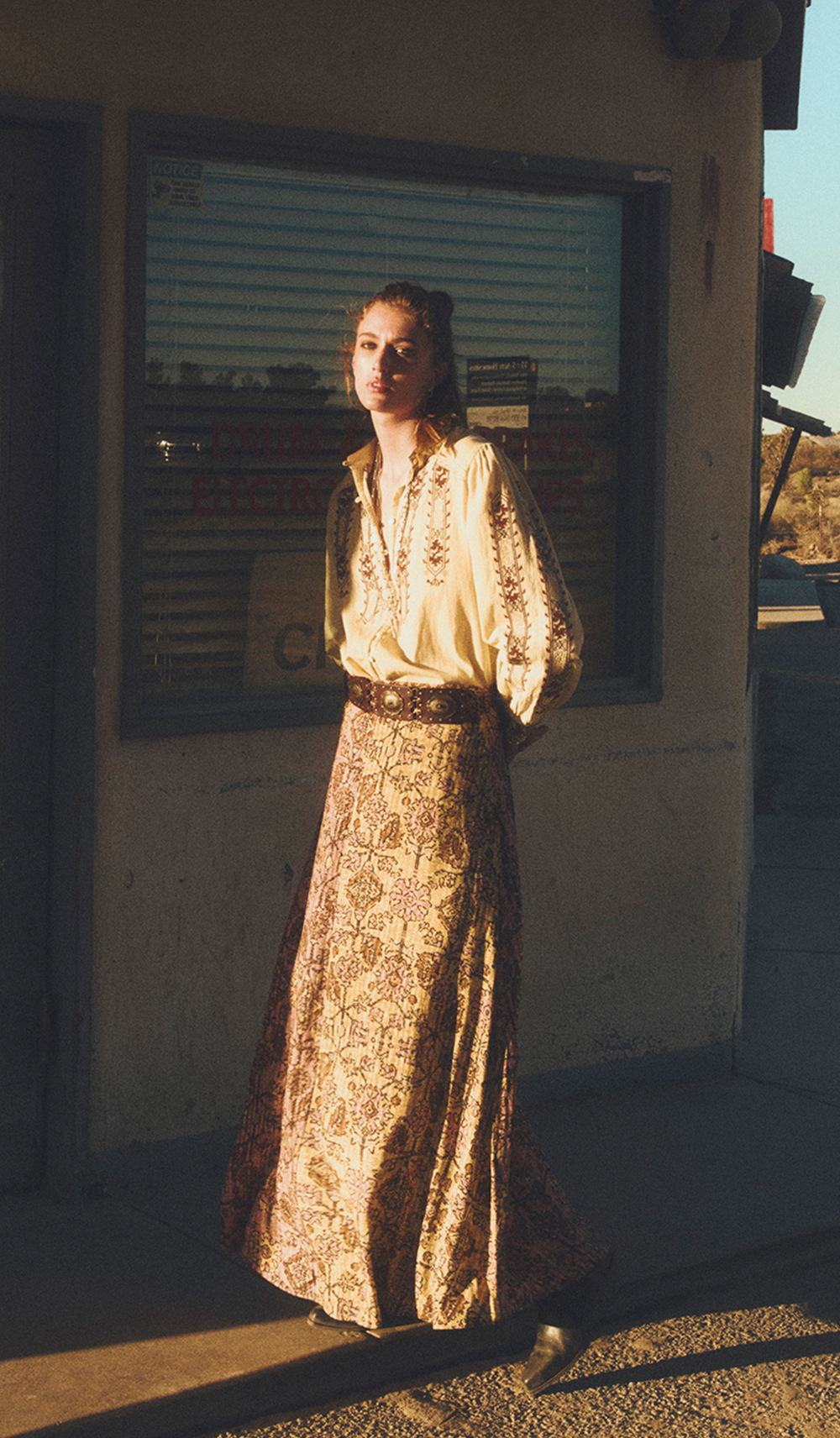 A model wearing a yellow embroidered blouse and a floral skirt 