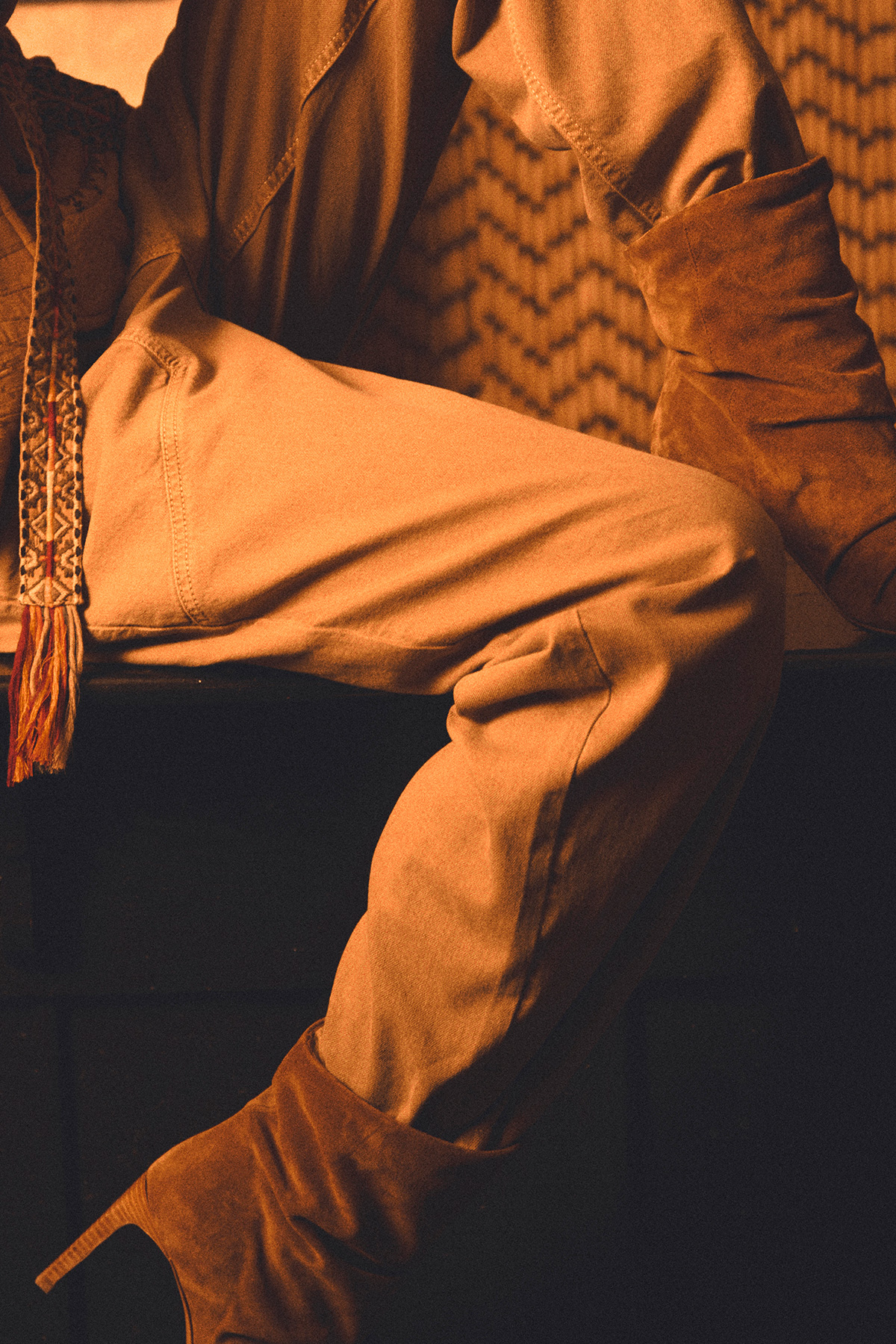 a model wearing beige pants and brown suede heeled boots