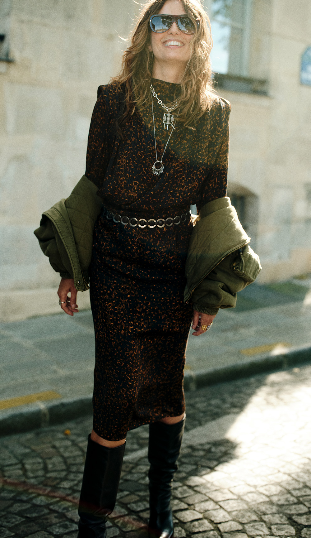 The model is wearing a long printed dress