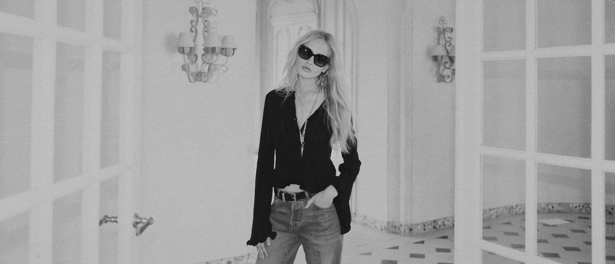 ba&sh friday, woman wearing a black top and sunglasses, the photo is in black and white. 