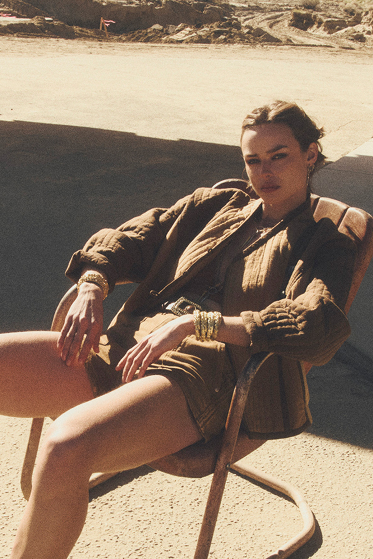 a model sitting on a chair wearing a jacket