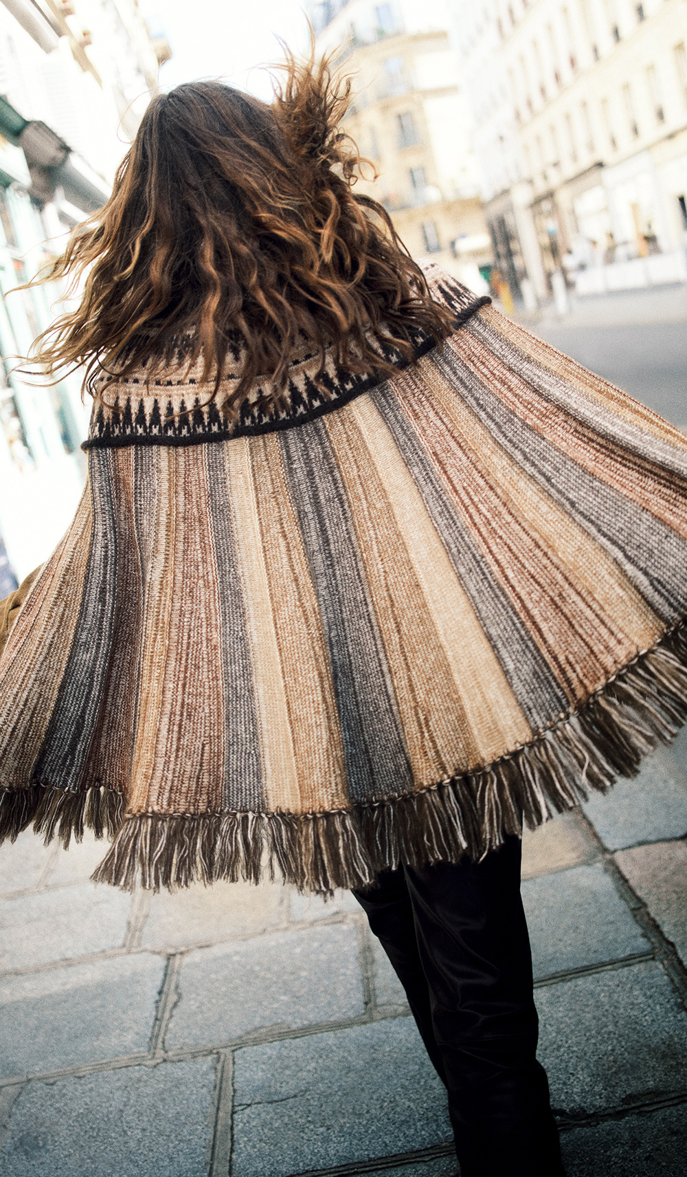The model is wearing a woollen poncho