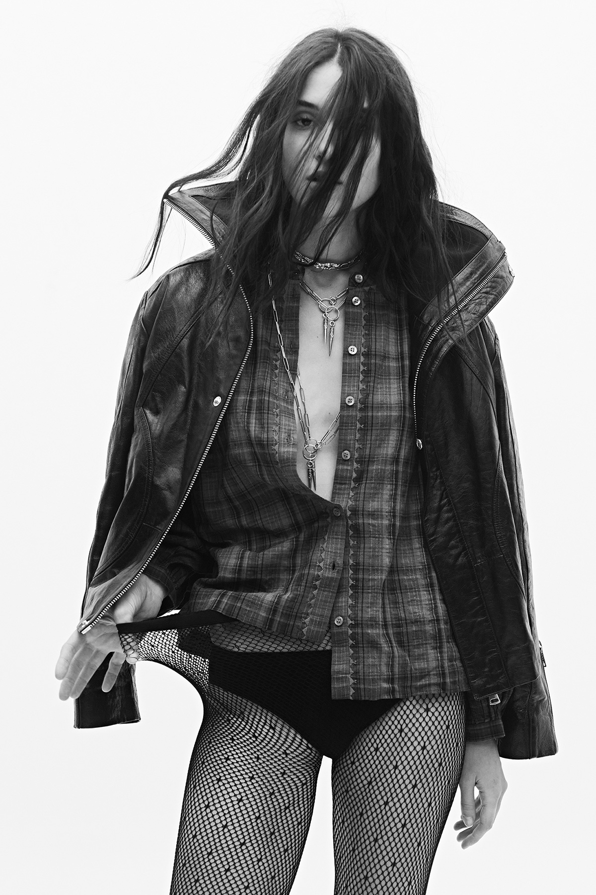 A model wearing a plaid shirt and a ba&sh leather jacket