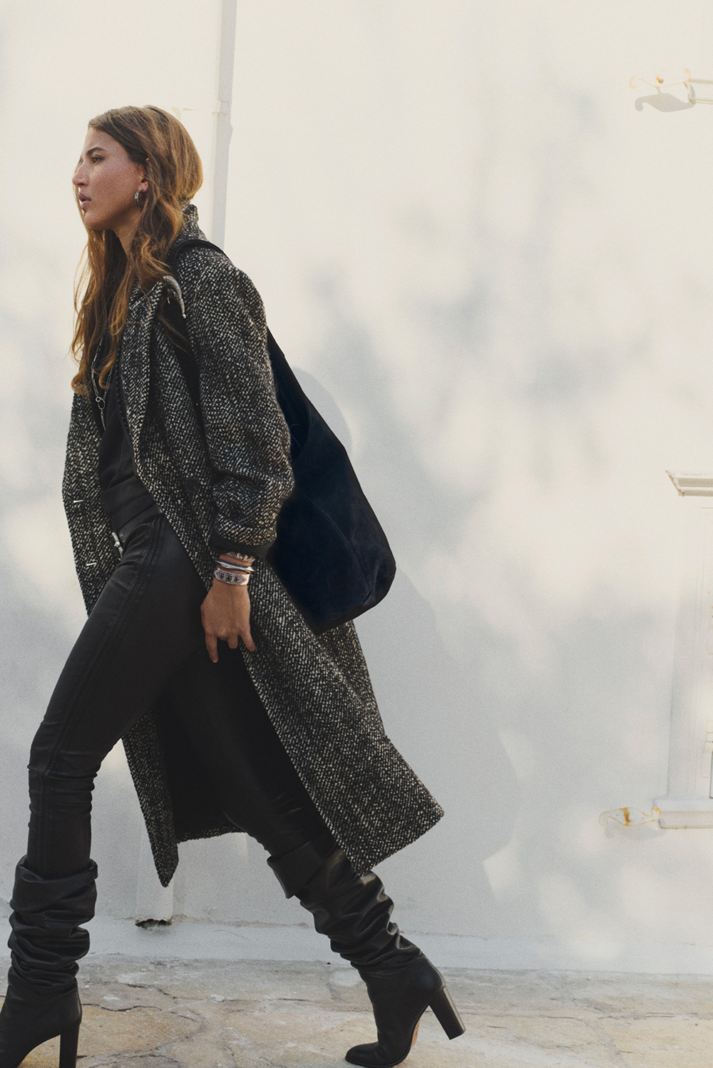 A model wearing a gray coat with black high boots
