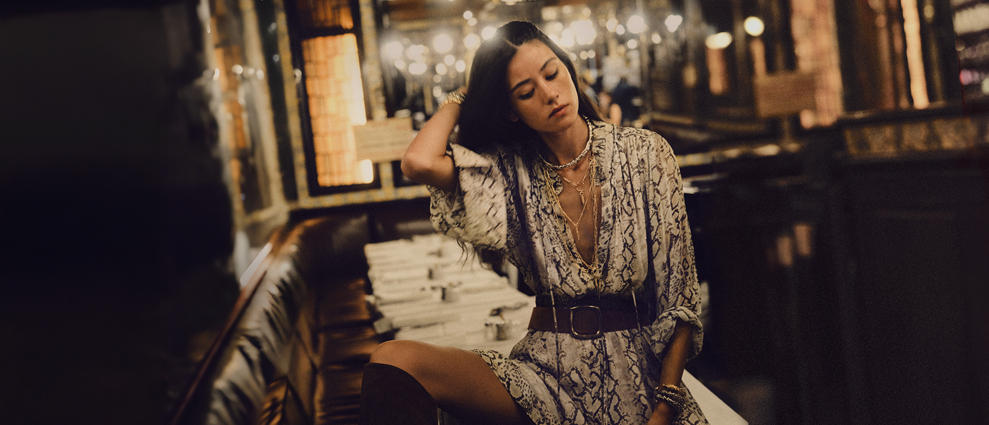 sale, woman wearing a white dress, seated on a table in a restaurant