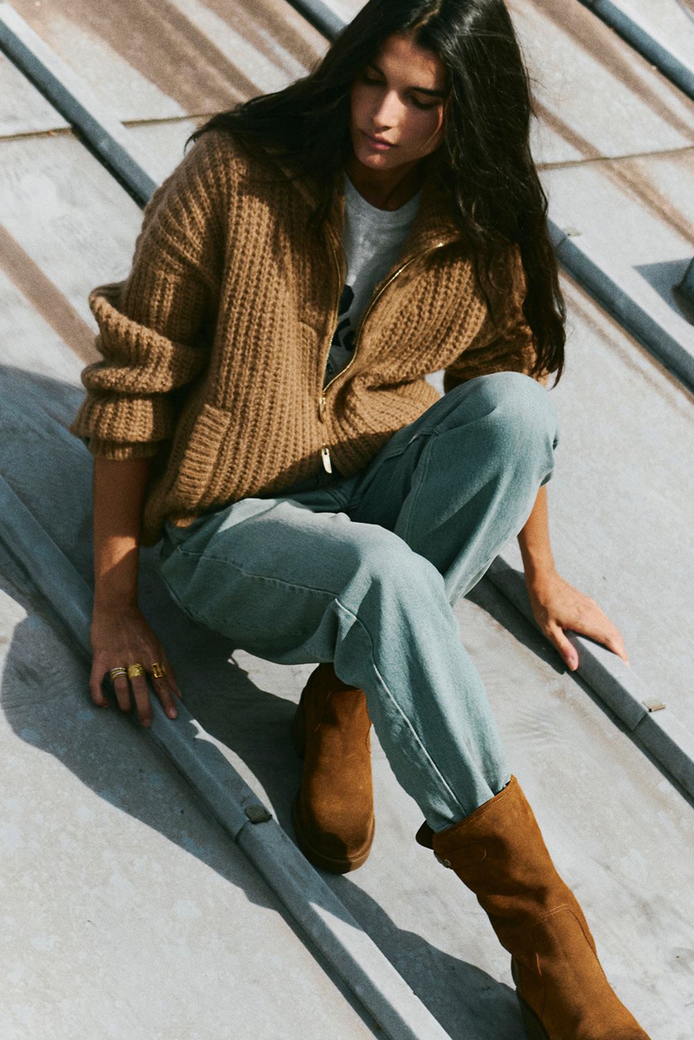 The model is wearing a knit sweater, jeans, and suede ankle boots