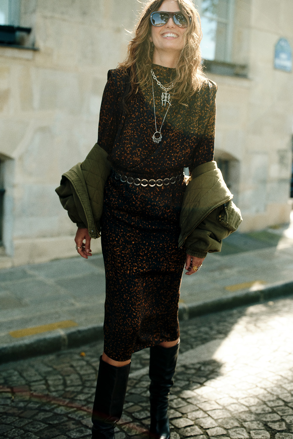 The model is wearing a long printed dress