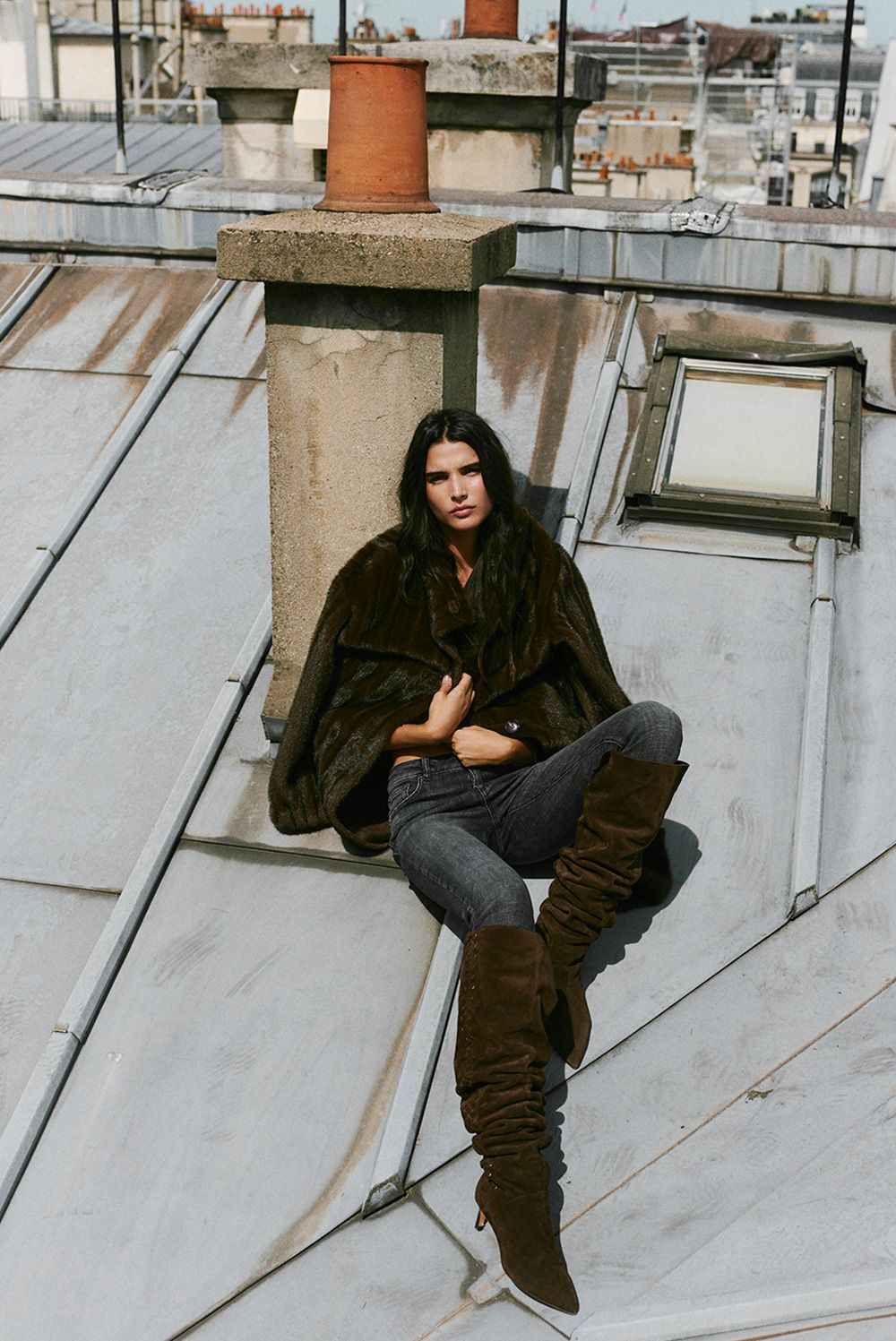 The model is wearing a pair of boots and jeans