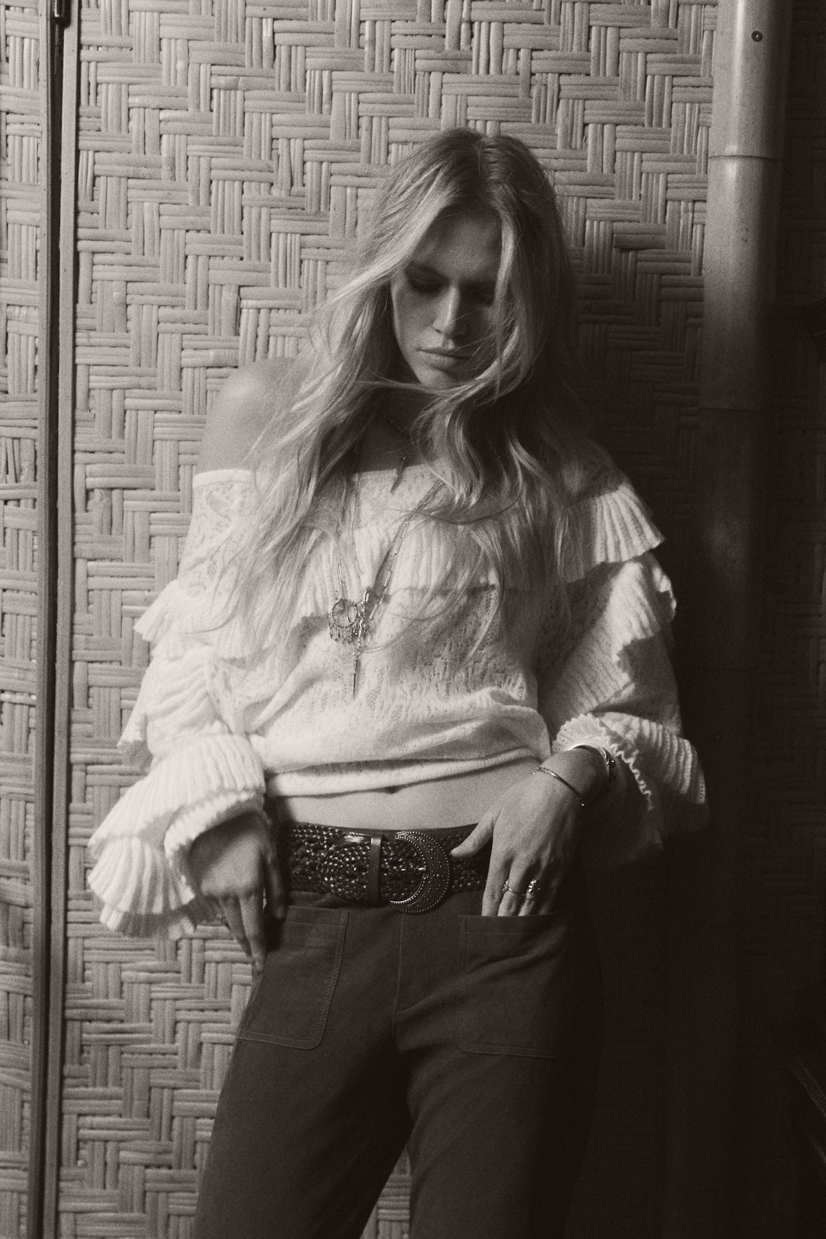 A model wearing a white ruffled jumper